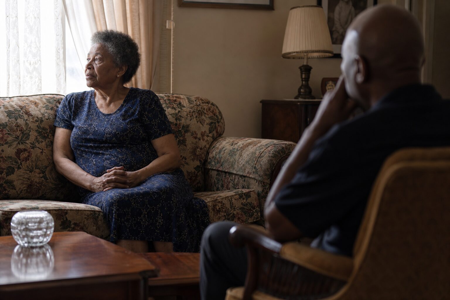 An elderly woman beginning to speak, gazing out the window