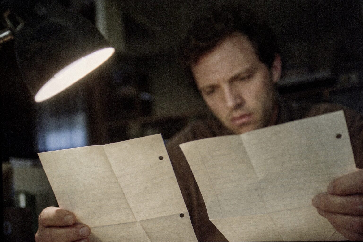 Hands comparing the same sentence written in two envelopes