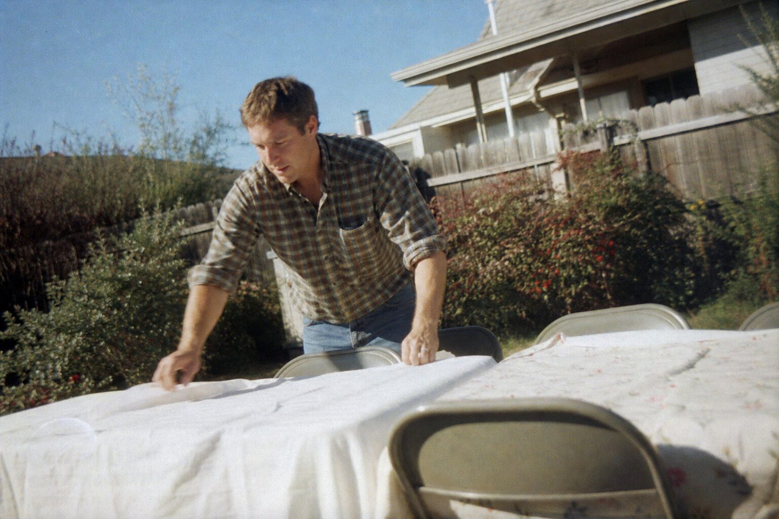 A man setting up the yard while another sends a message