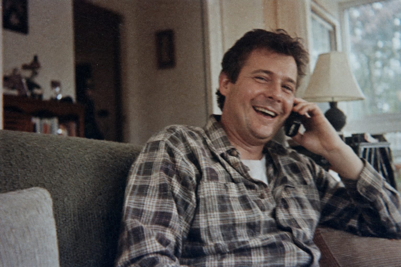 Two men talking happily on their smartphones