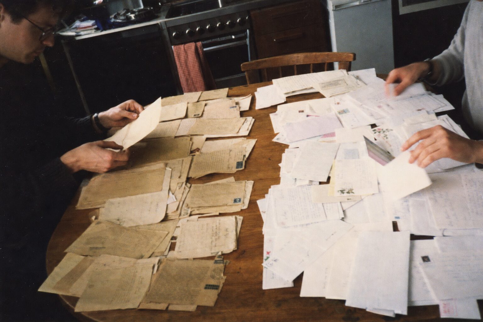 A woman's hands comparing multiple letters spread on a table