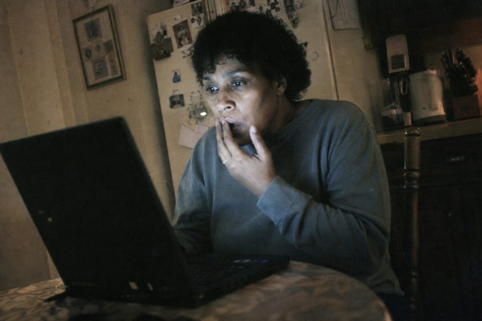 A woman staring at a reply email on her laptop screen