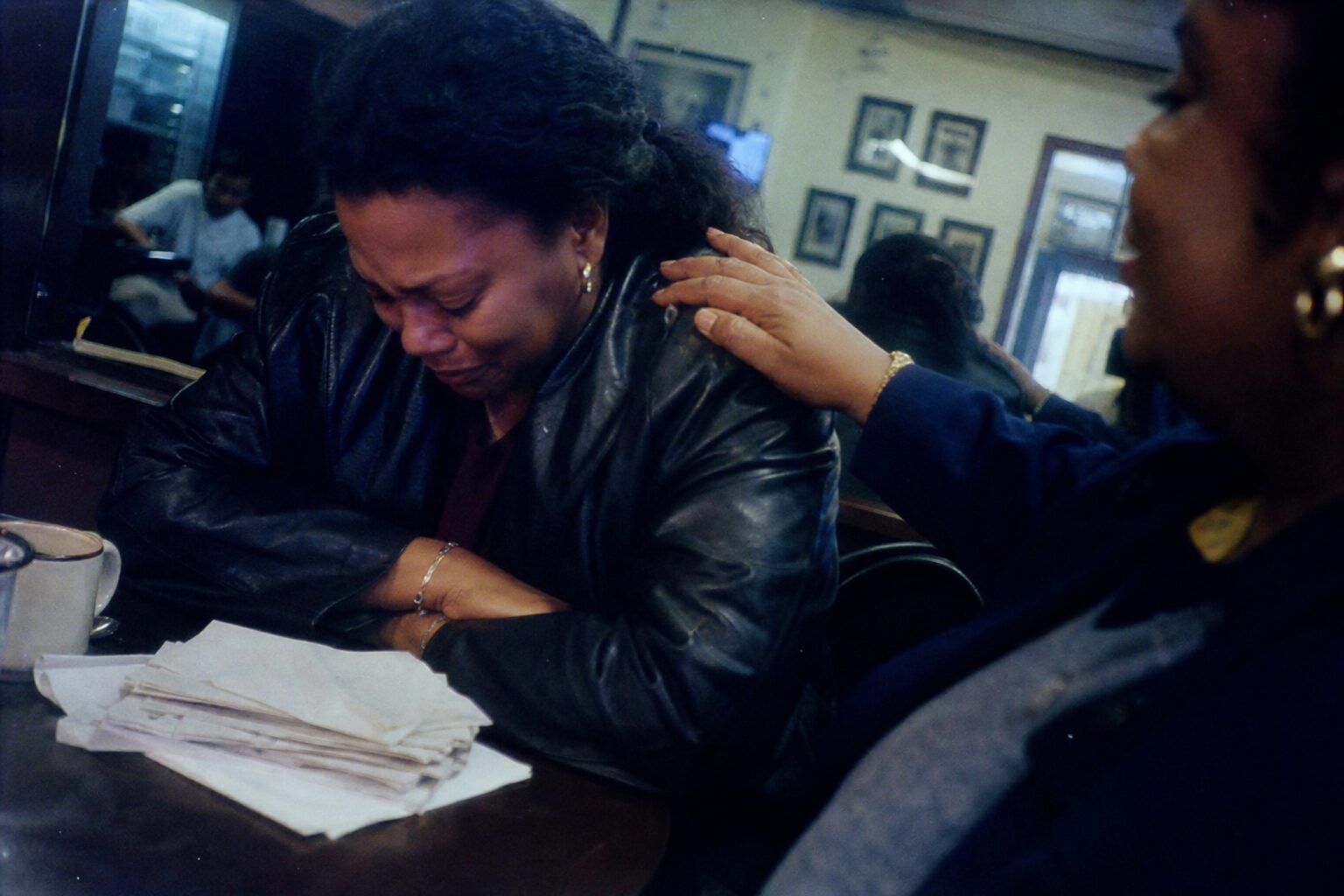 An older sister placing her hand on her crying younger sister's shoulder