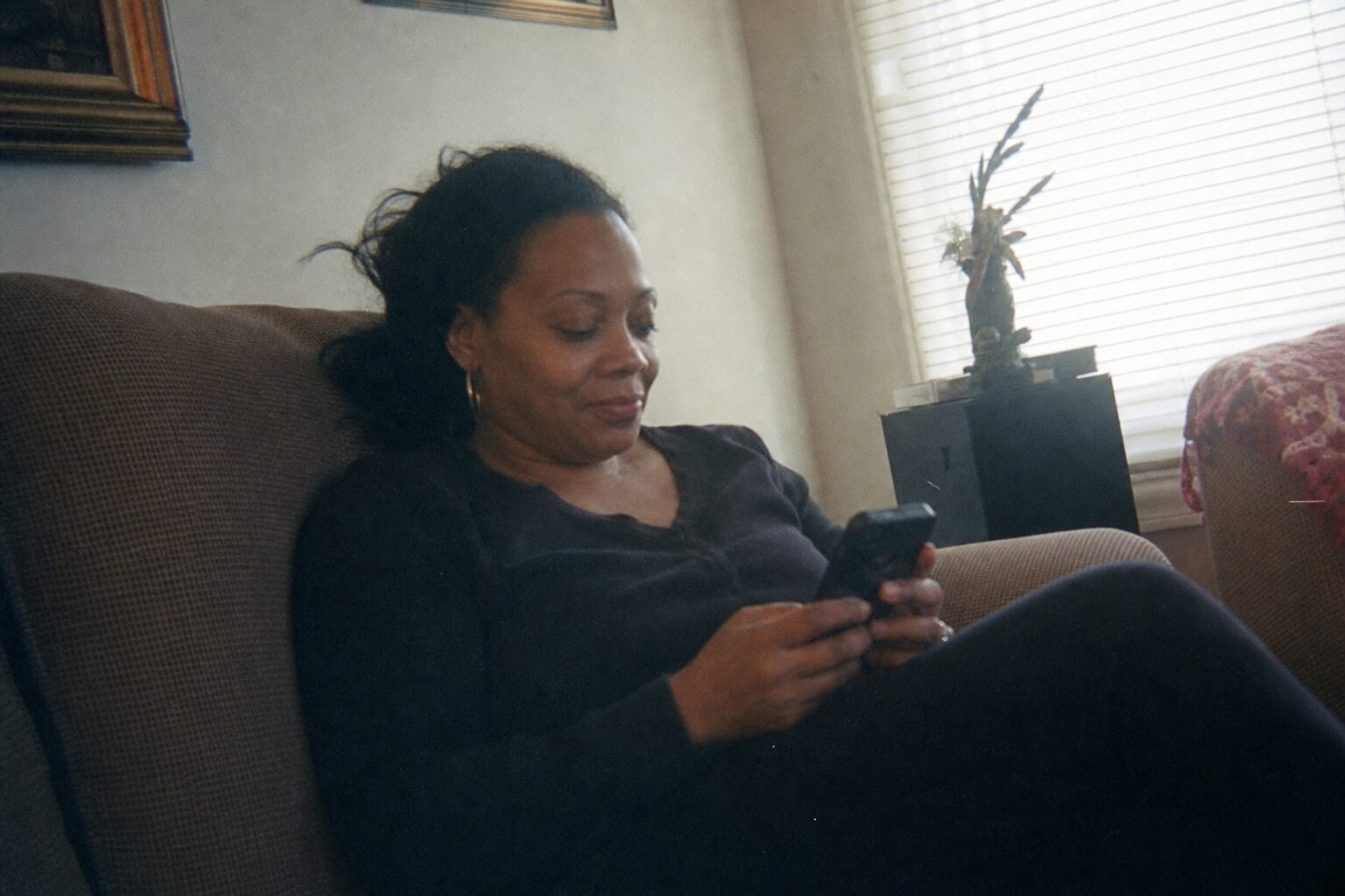 A woman reading a message on her phone with a quiet nod
