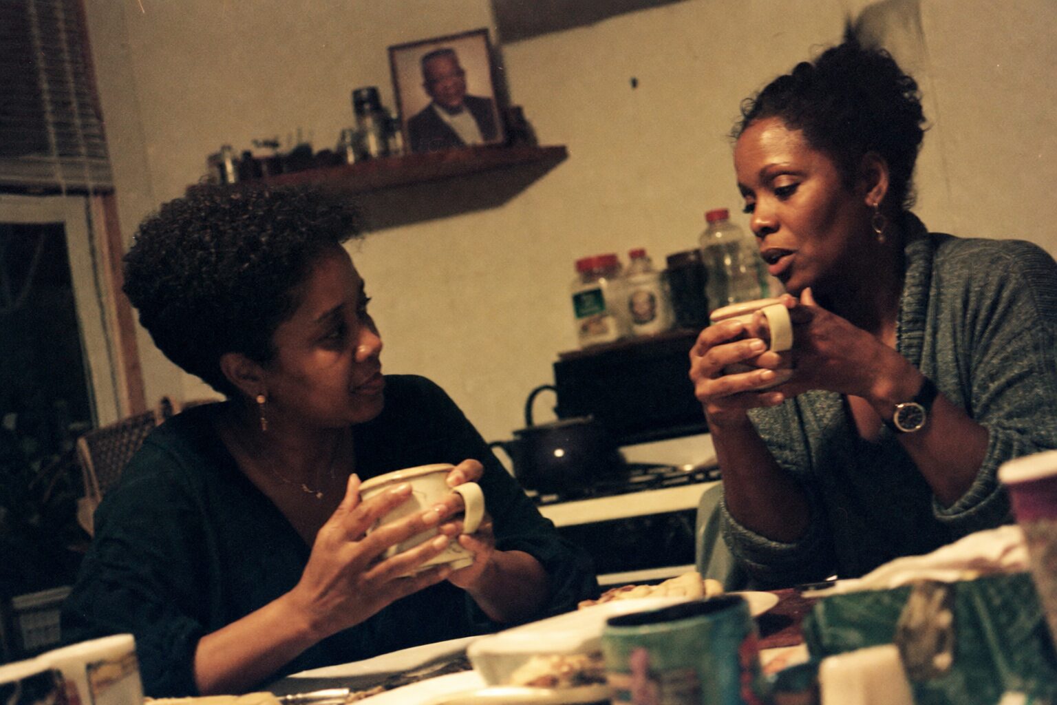 Two sisters drinking tea and talking quietly late at night